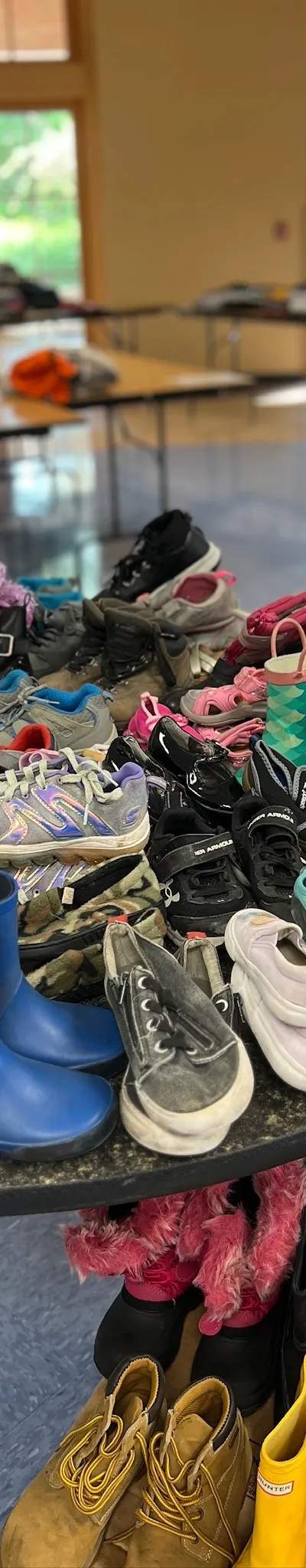 Tables of children's shoes and boots laid out at the Family Clothing Giveaway