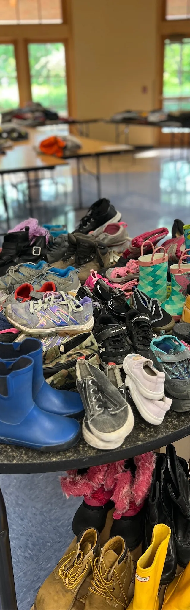 Tables of children's shoes and boots laid out at the Family Clothing Giveaway