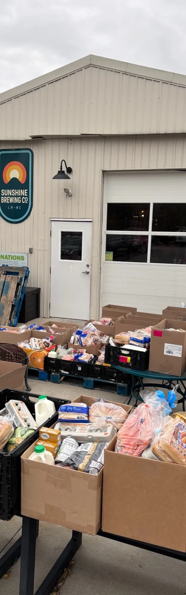 Crates and boxes of bread, milk, and produce set out for the monthly food pantry