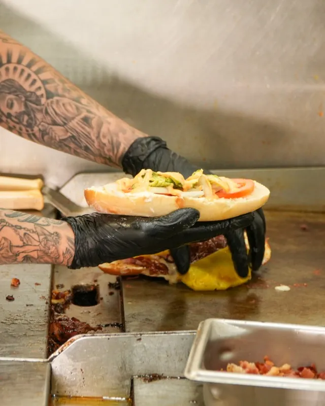 A cook working the flat top griddle in the Speedy Tacos kitchen