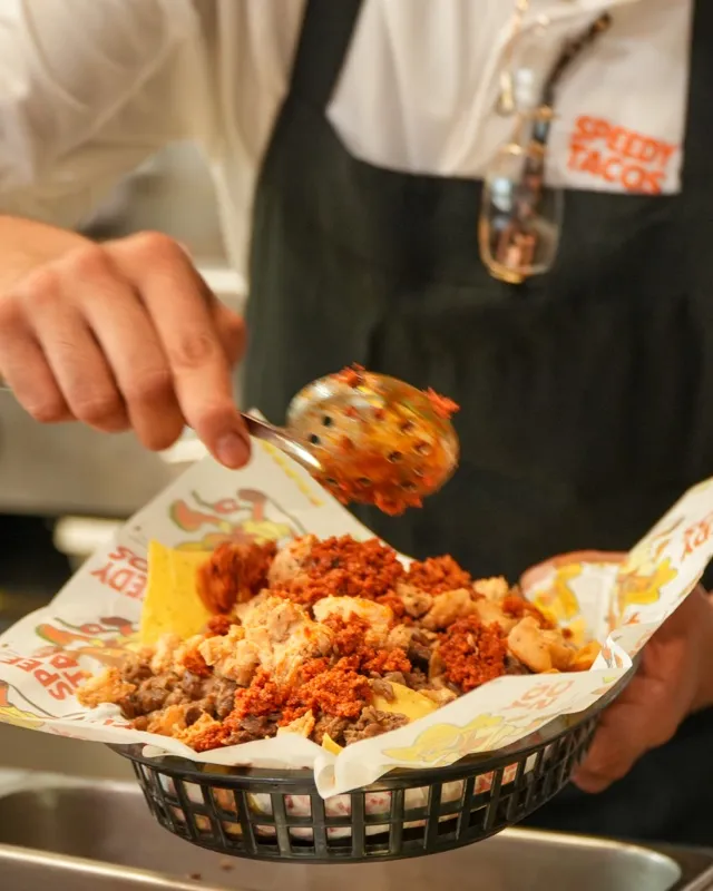 An order being plated into a basket at the Speedy Tacos counter