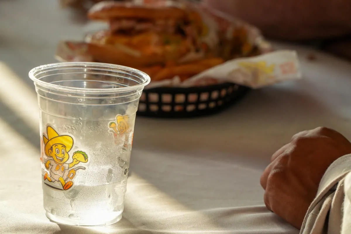 A branded Speedy Tacos cup beside a basket of food on the counter
