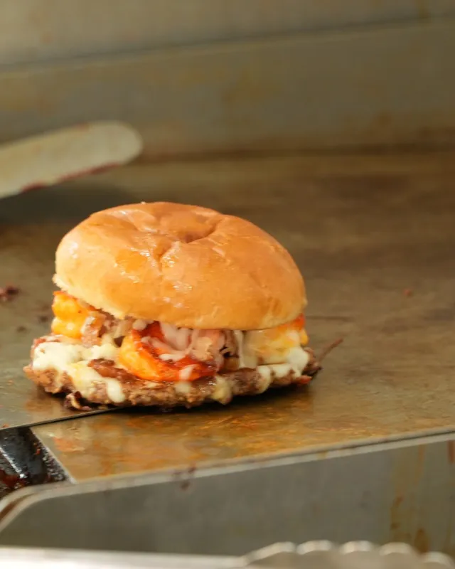 A sandwich cooking on the flat top griddle