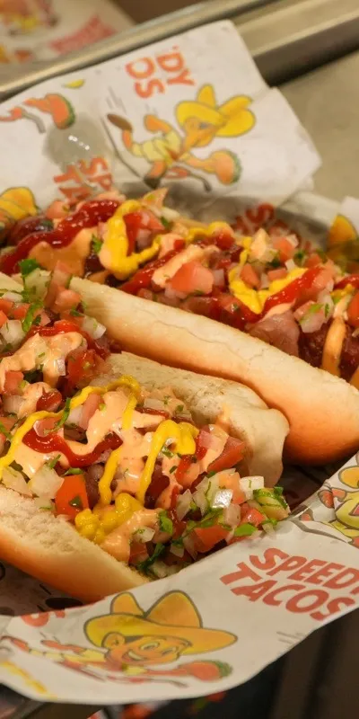 Two dressed hot dogs on Speedy Tacos paper